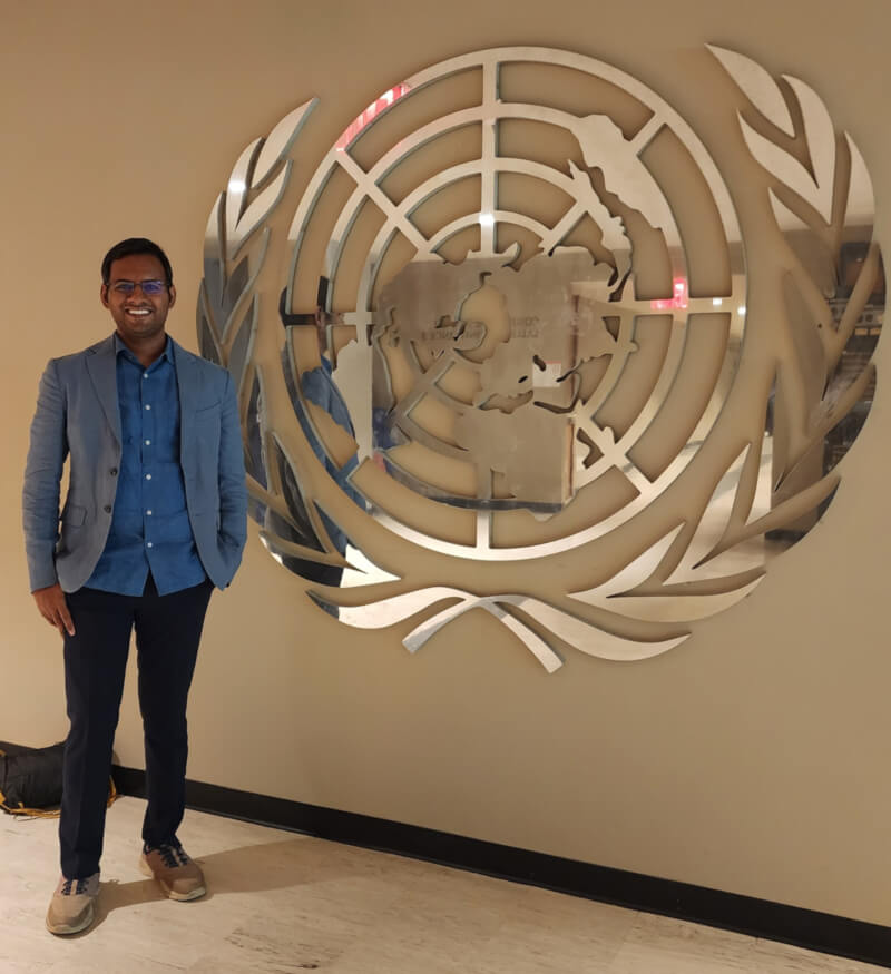 The articleās author, Vineel Reddy Pindi, posing beside the United Nations emblem.